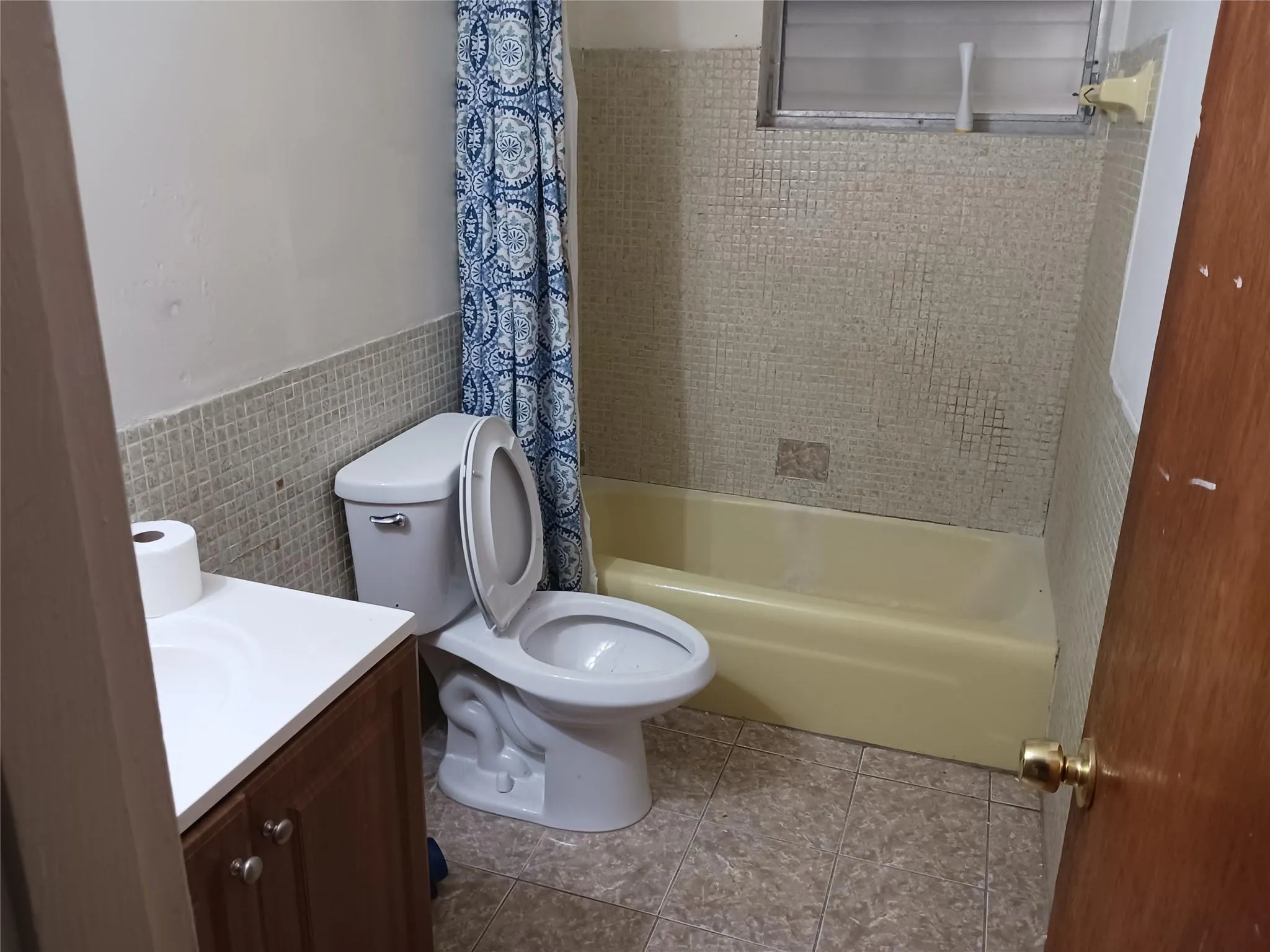 Bathroom featuring a built-in bathtub, a toilet, and a vanity with a white countertop