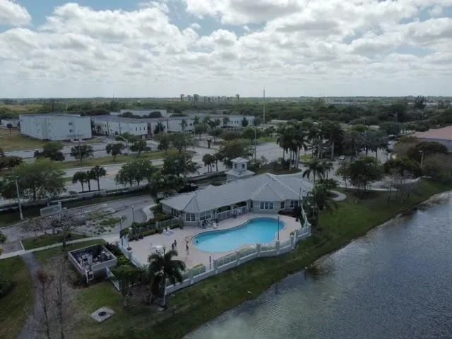 Community amenities featuring a clubhouse with a pool, surrounding patio, and waterfront access