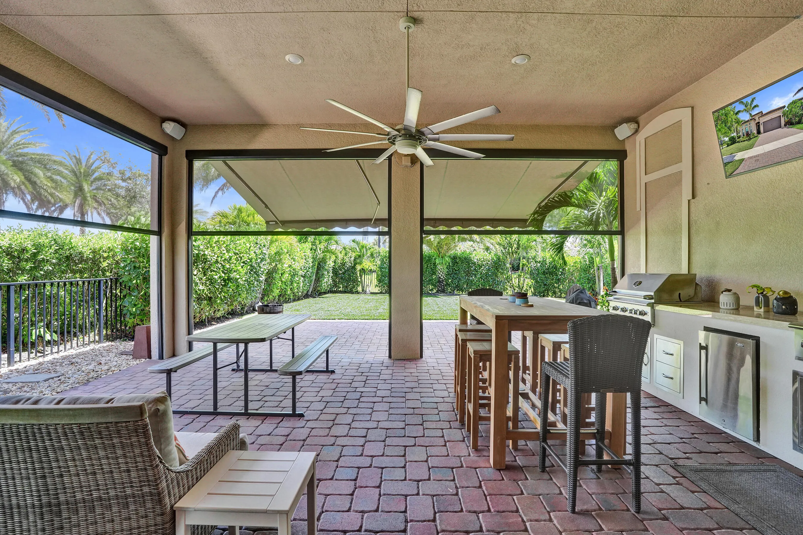 Outdoor living at its best w this extended patio, outdoor kitchen, motorized screens and motorized awning