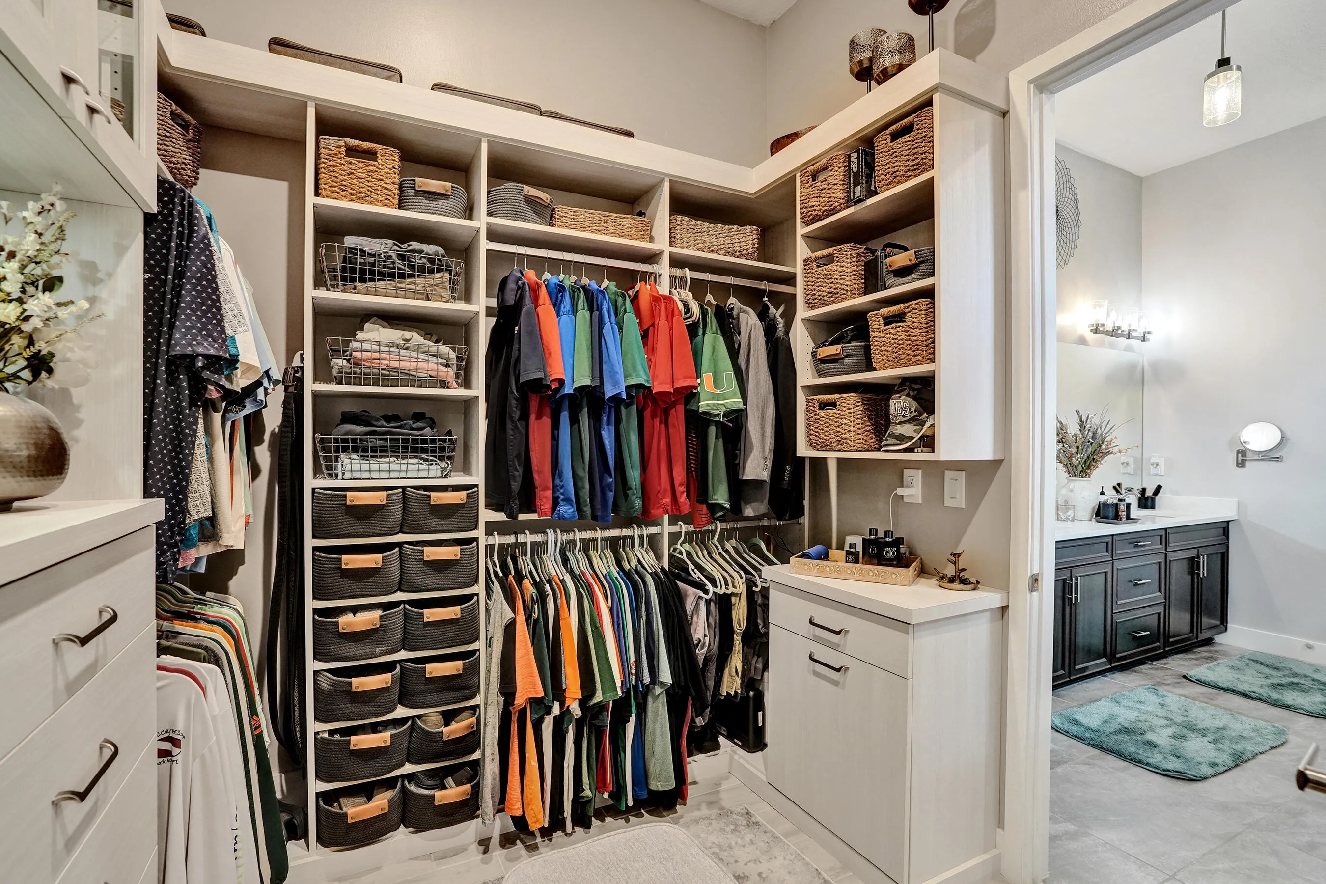 Expansive walk-in closet featuring extensive built-in shelving, multiple hanging rods, integrated drawers
