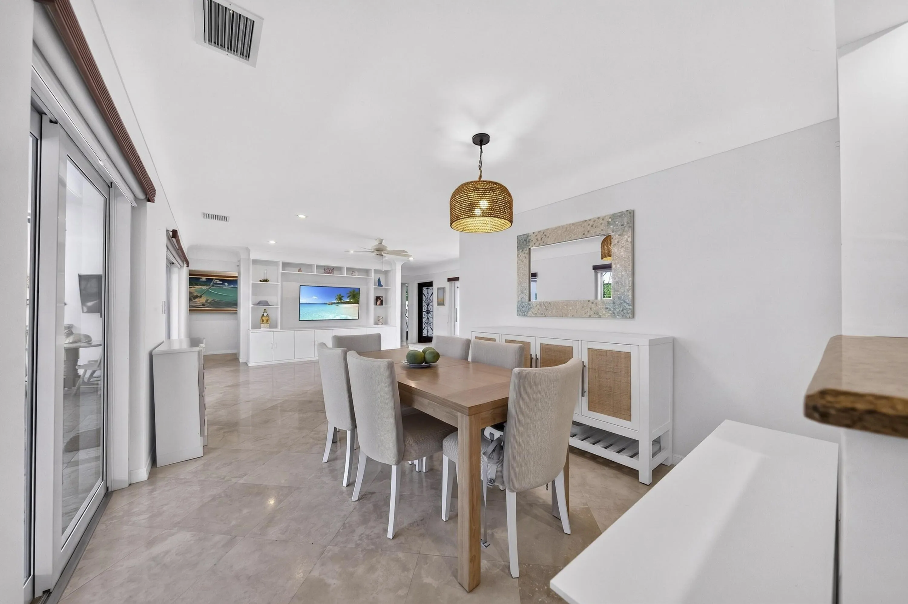 Open-concept living area featuring light-toned flooring, white walls, and a recessed ceiling with integrated lighting