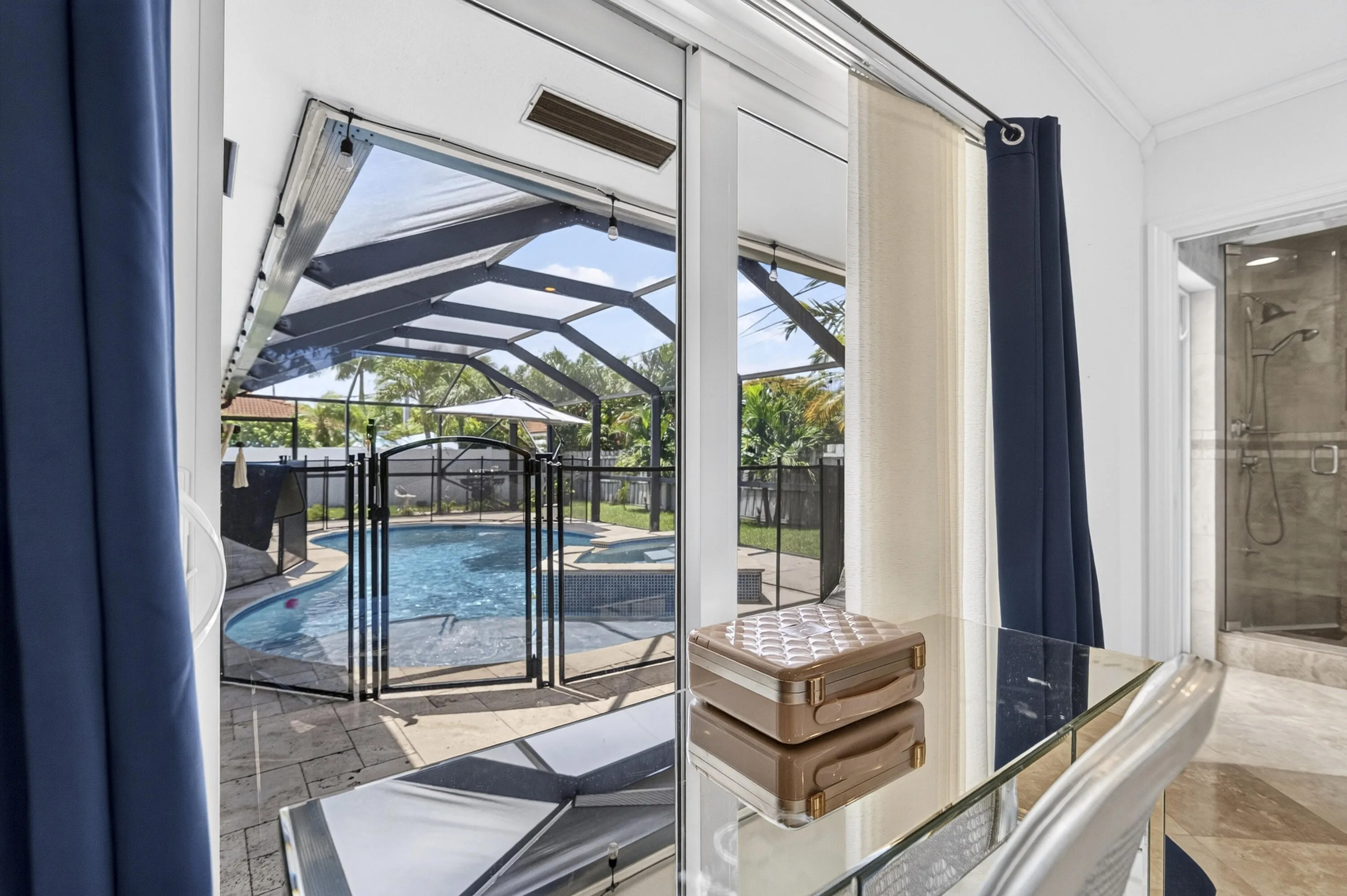 Sliding glass doors opening to a screened lanai with a pool and built-in spa