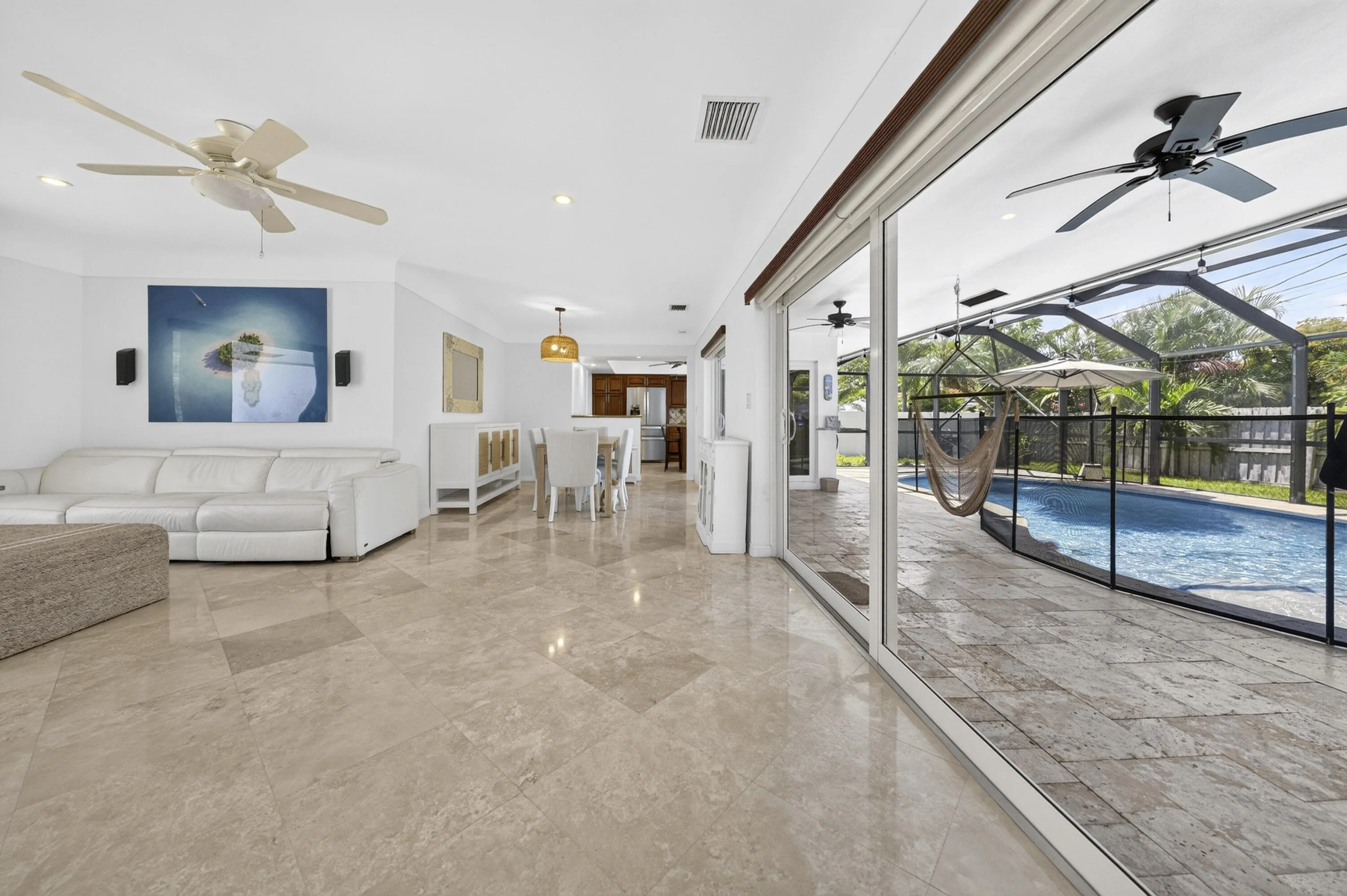 Spacious interior featuring large format Travertine marble flooring, recessed lighting, and a ceiling fan