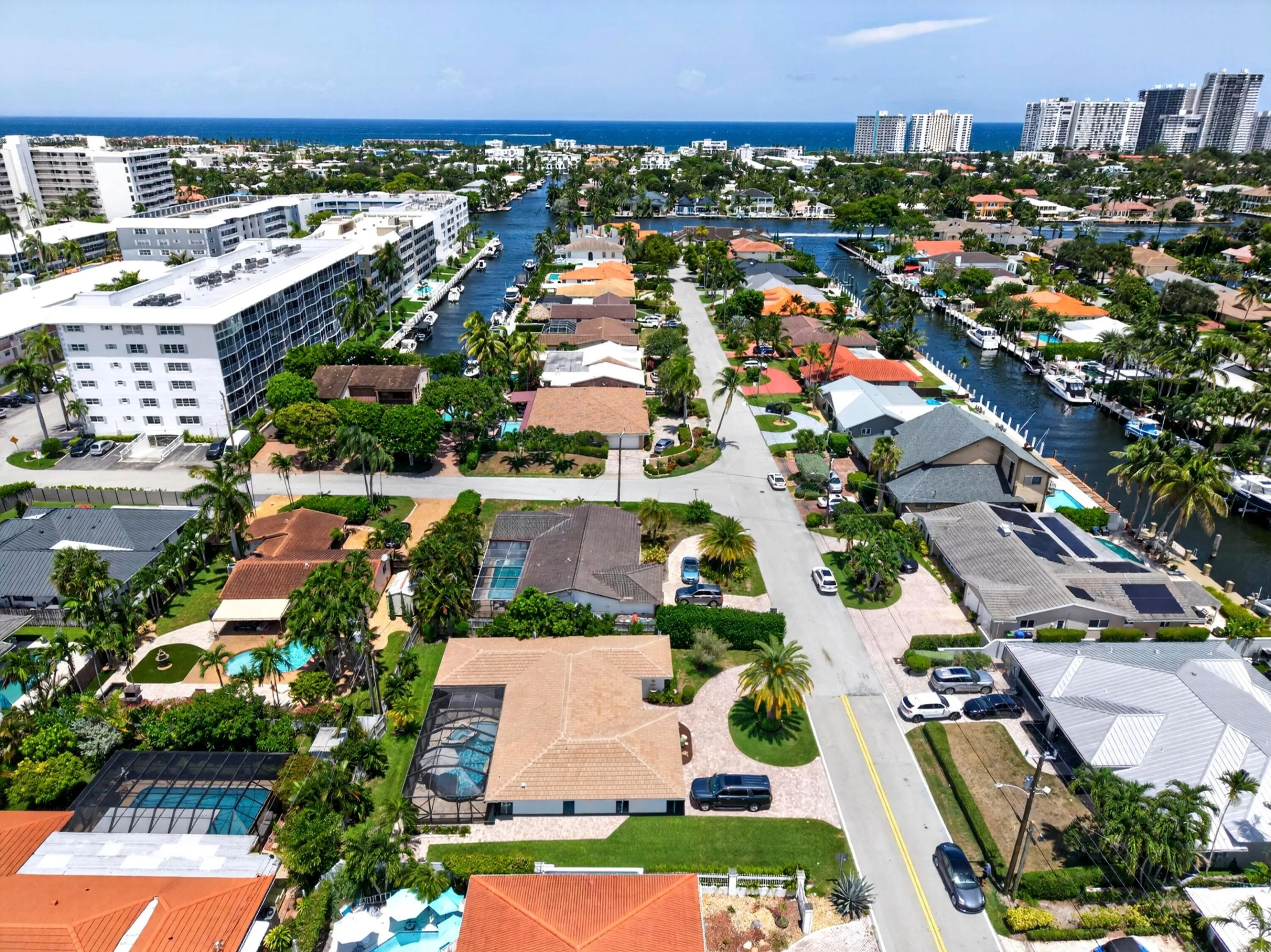Aerial perspective featuring a residential street with properties offering private swimming pools, manicured landscaping