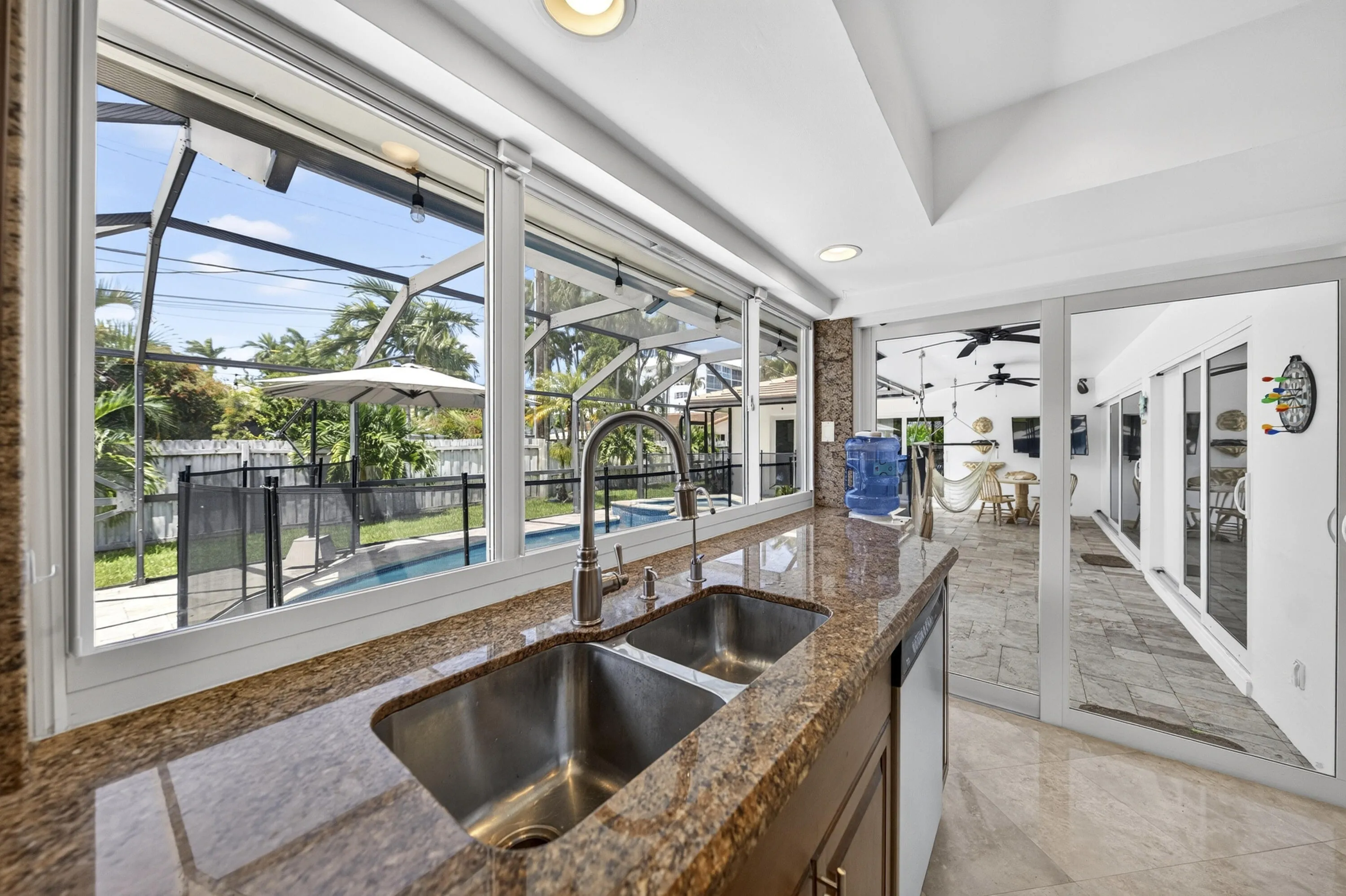 Kitchen featuring a double basin stainless steel sink, granite countertops, and wood cabinetry