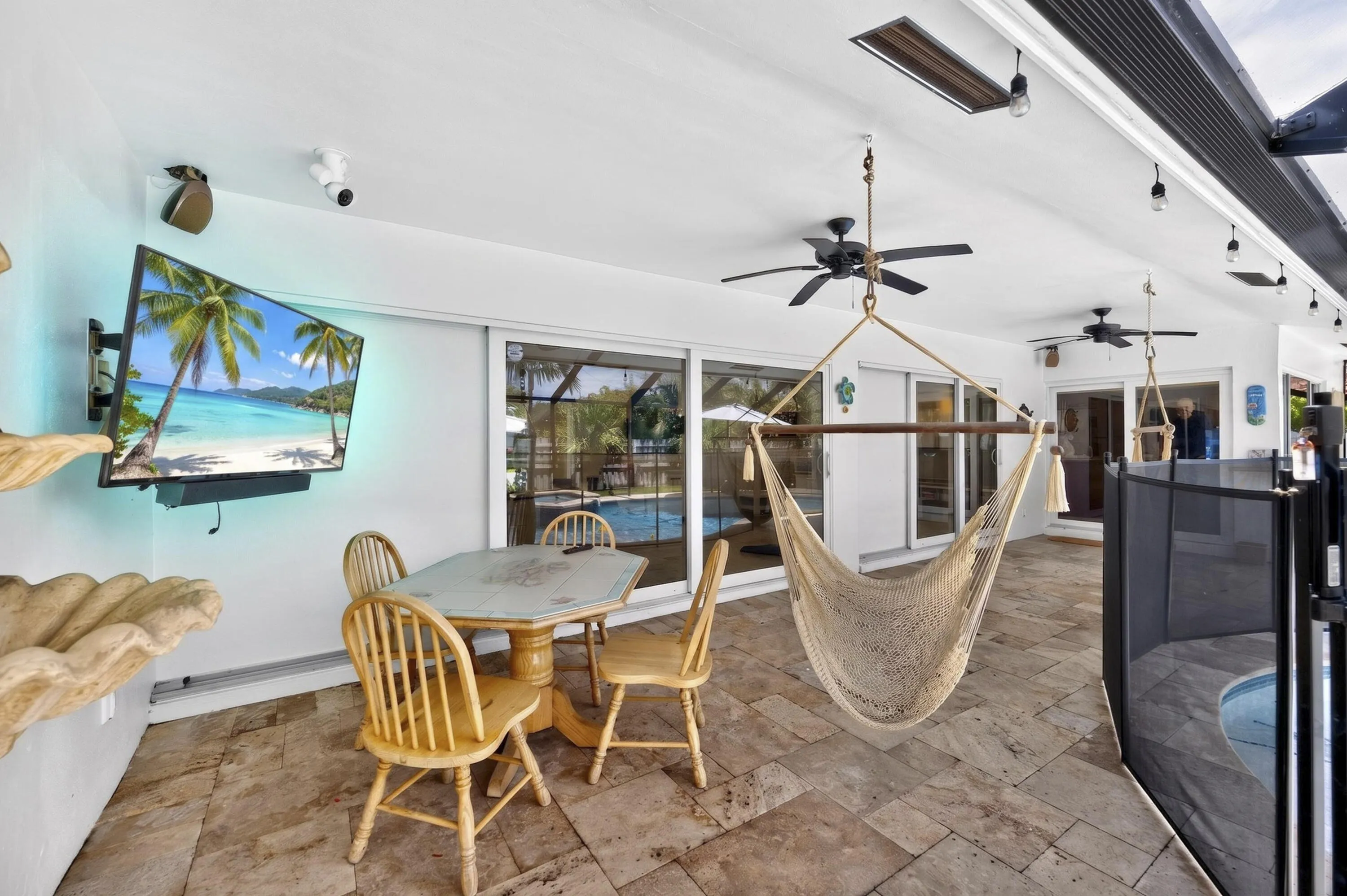 Covered patio featuring stone-finish flooring and multiple ceiling fans