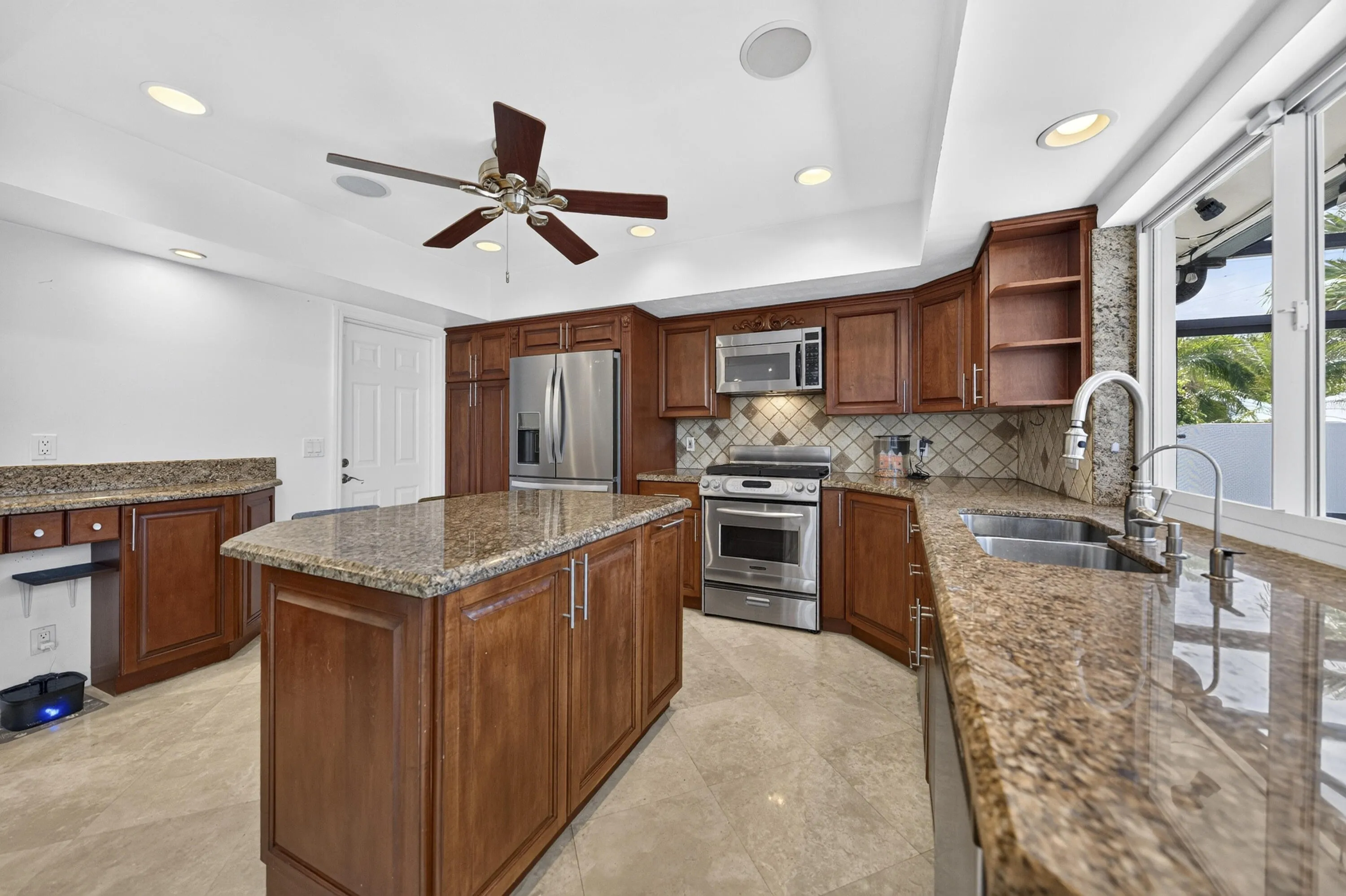 Kitchen with wood cabinetry, granite countertops, and stainless steel appliances