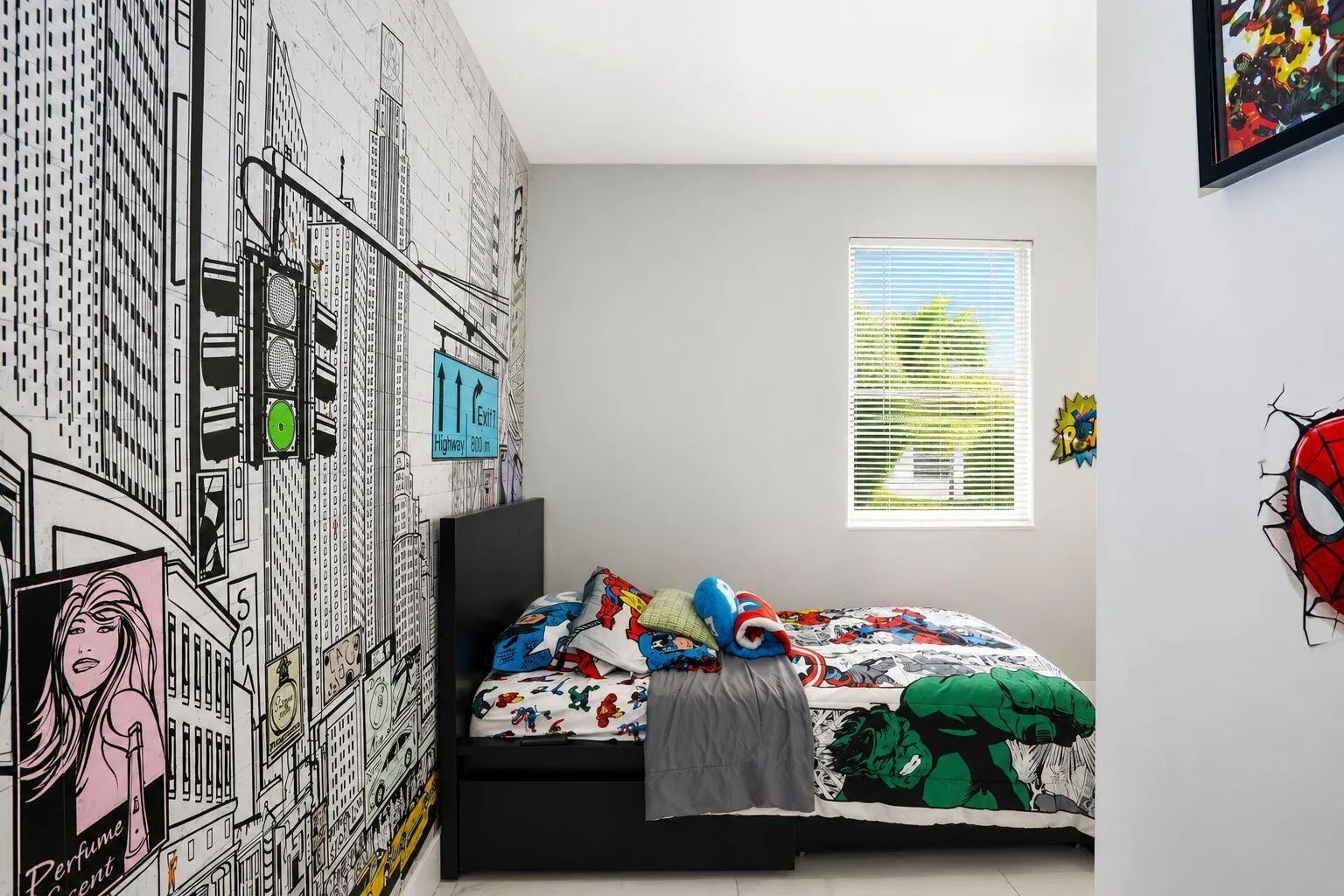 Well-lit interior room featuring a large window with horizontal blinds, a city-themed accent wall, and light-toned flooring