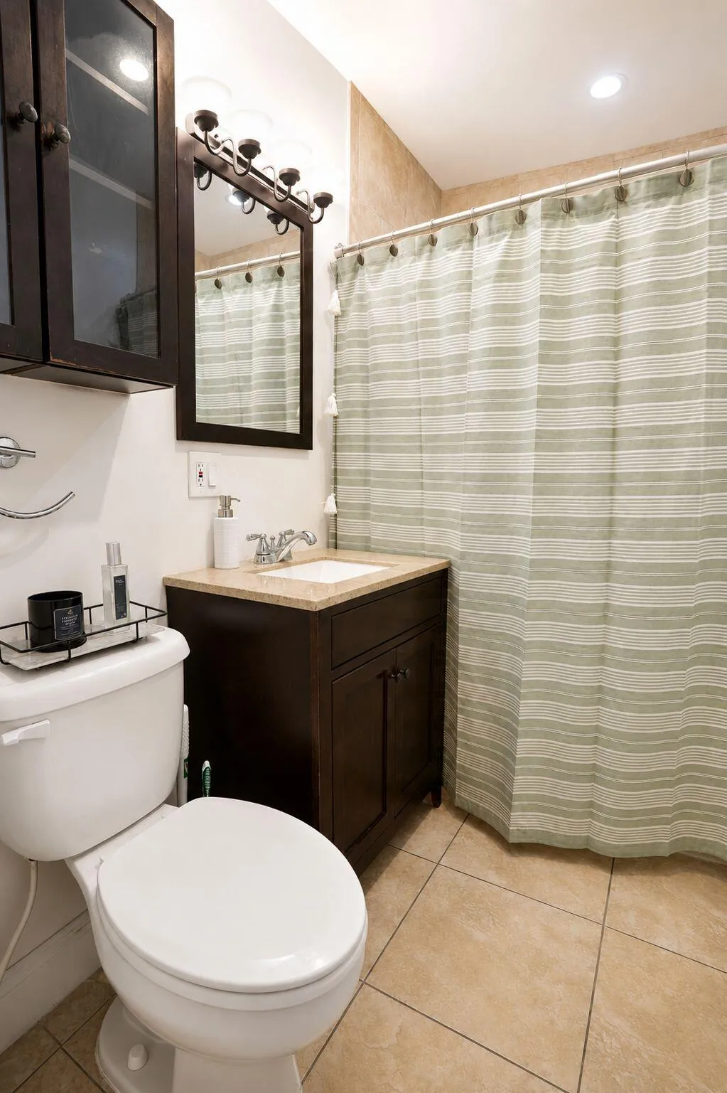 Bathroom featuring a dark wood-finish vanity with a light-toned countertop, a built-in sink, and coordinating storage cabinetry