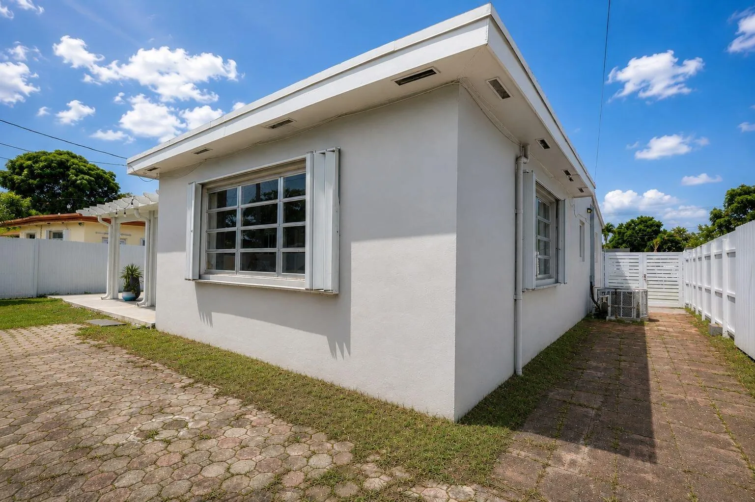 Stucco exterior with a flat roofline and roll-down storm shutters