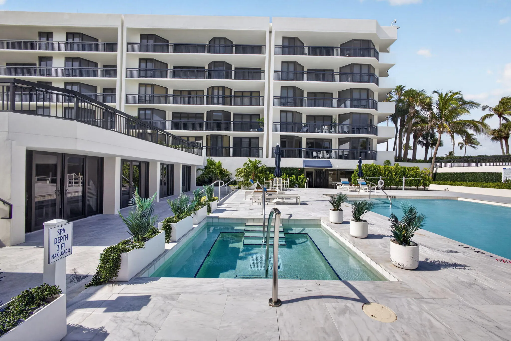 Resort-style pool deck featuring a swimming pool, spa, and ample lounging space