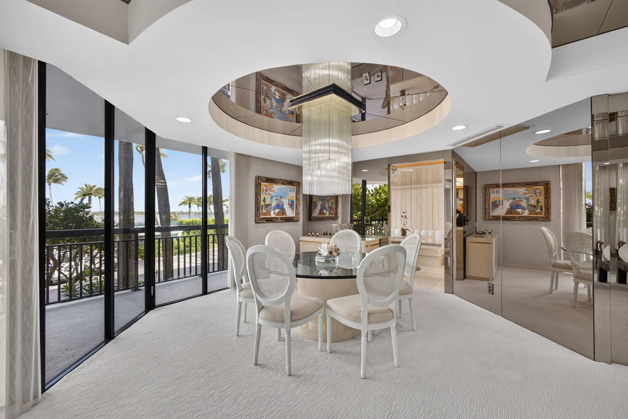 Dining area featuring floor-to-ceiling glass panel windows with outdoor access and a palm tree backdrop