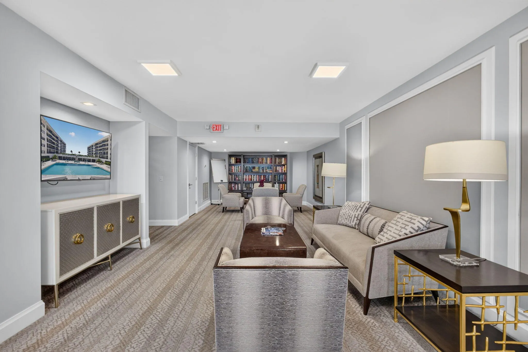 Lounge area featuring patterned carpeting, recessed ceiling lighting, decorative wall molding, and a built-in media niche with cabinetry