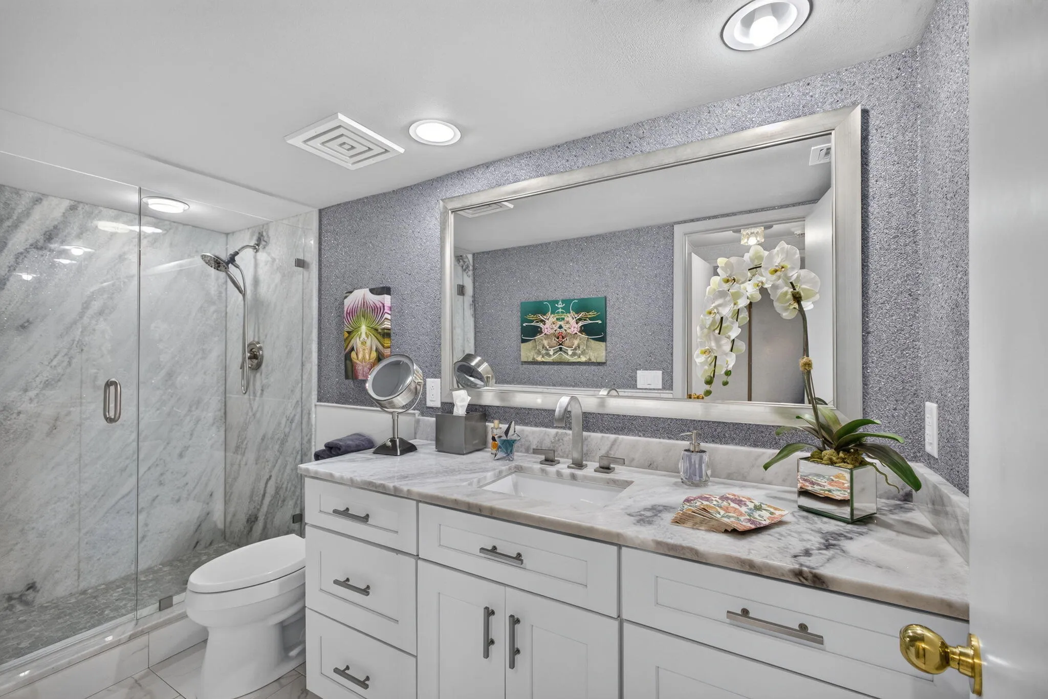 Bathroom featuring a white vanity with integrated sink, stone countertop, and a large wall-mounted mirror