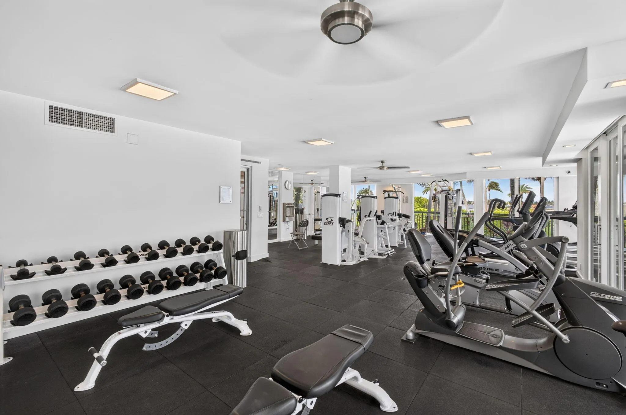 Spacious fitness center featuring rubber flooring, recessed lighting, and large windows