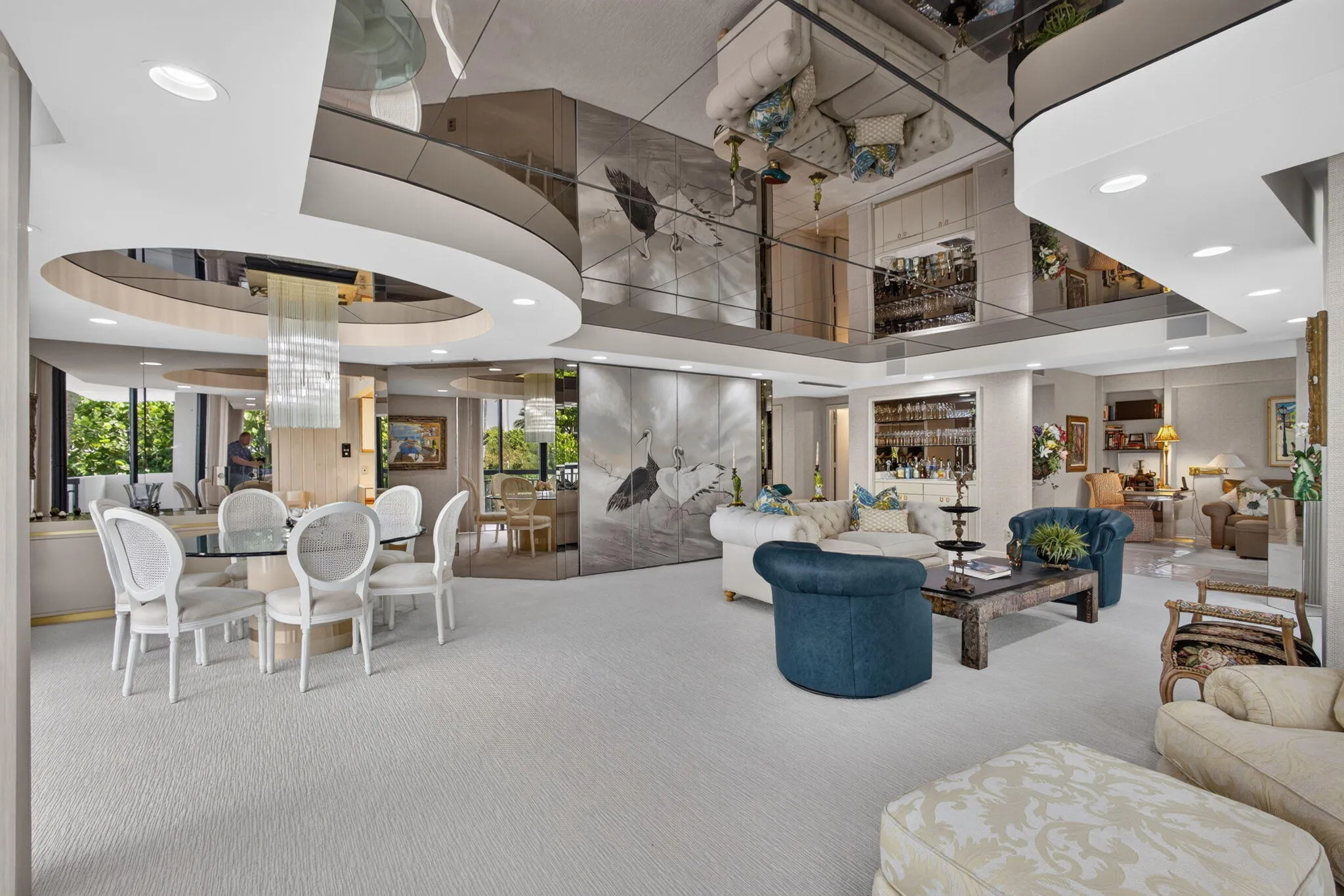 Expansive living space featuring a distinct dining area with a glass-top table