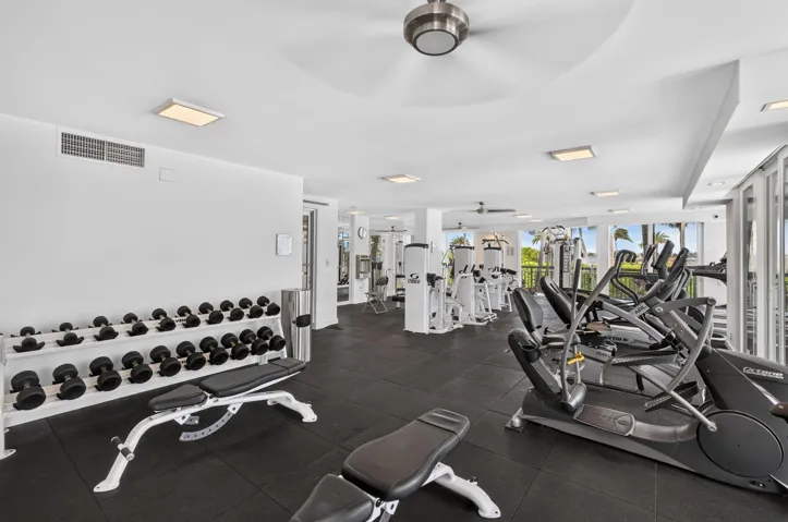 Spacious fitness center featuring rubber flooring, recessed lighting, and large windows