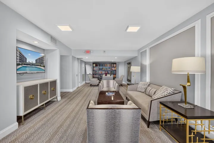 Lounge area featuring patterned carpeting, recessed ceiling lighting, decorative wall molding, and a built-in media niche with cabinetry