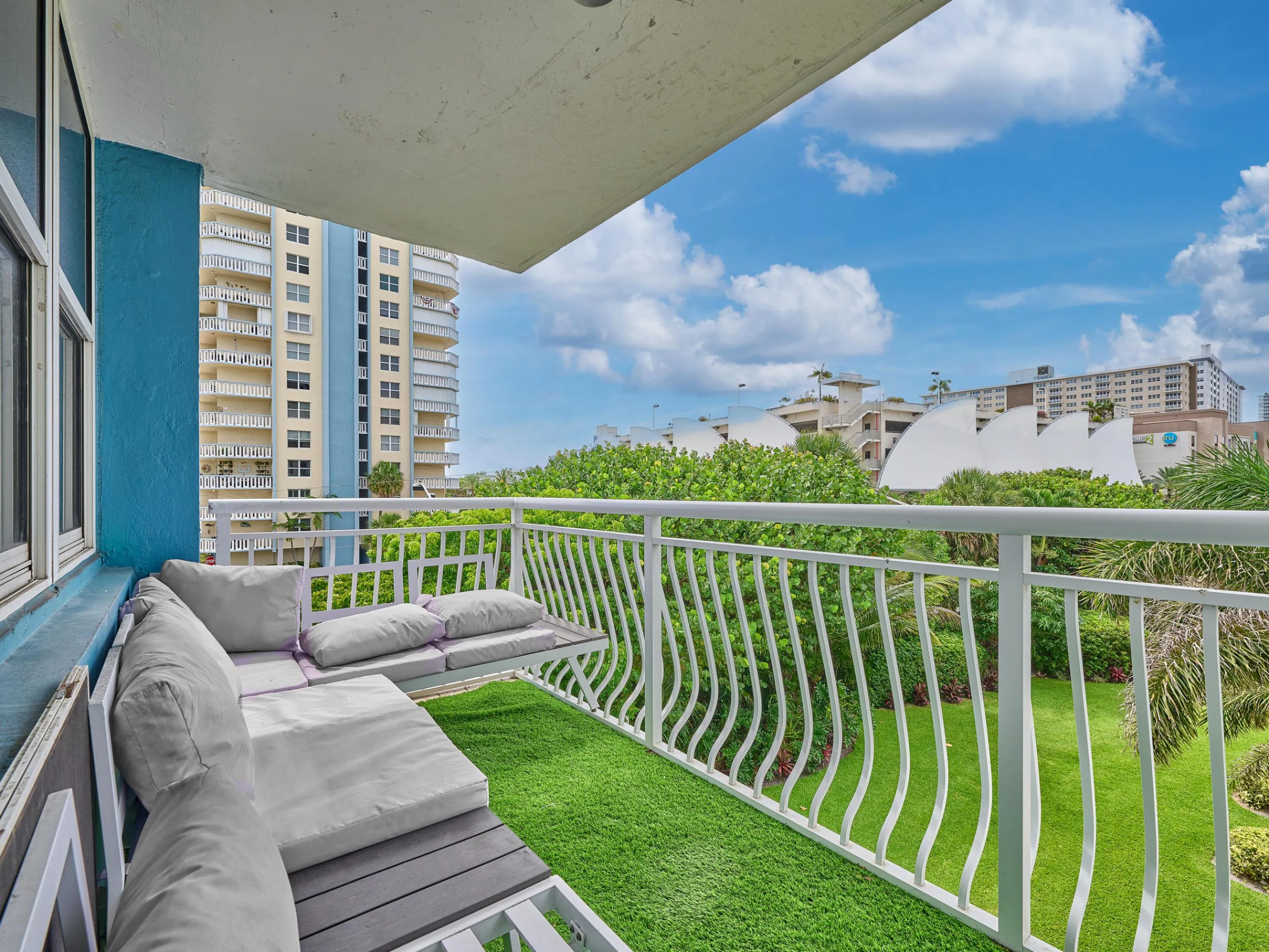 Balcony | Enjoy beautiful views of the swimming pool, lush landscaping, and blue skies.