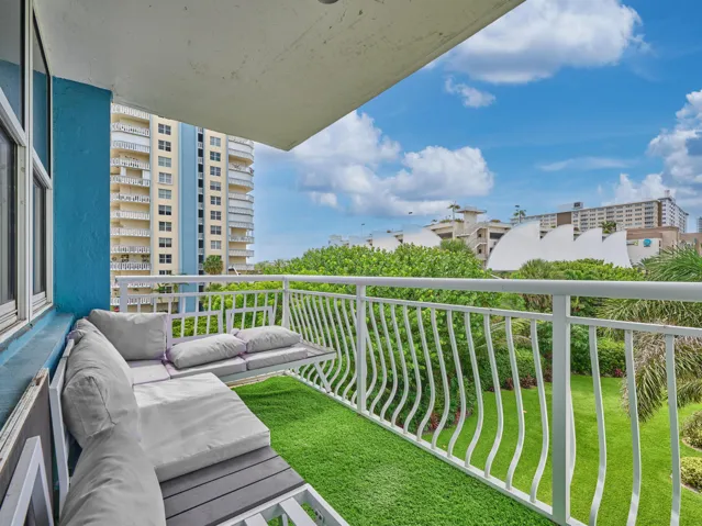 Balcony | Enjoy beautiful views of the swimming pool, lush landscaping, and blue skies.