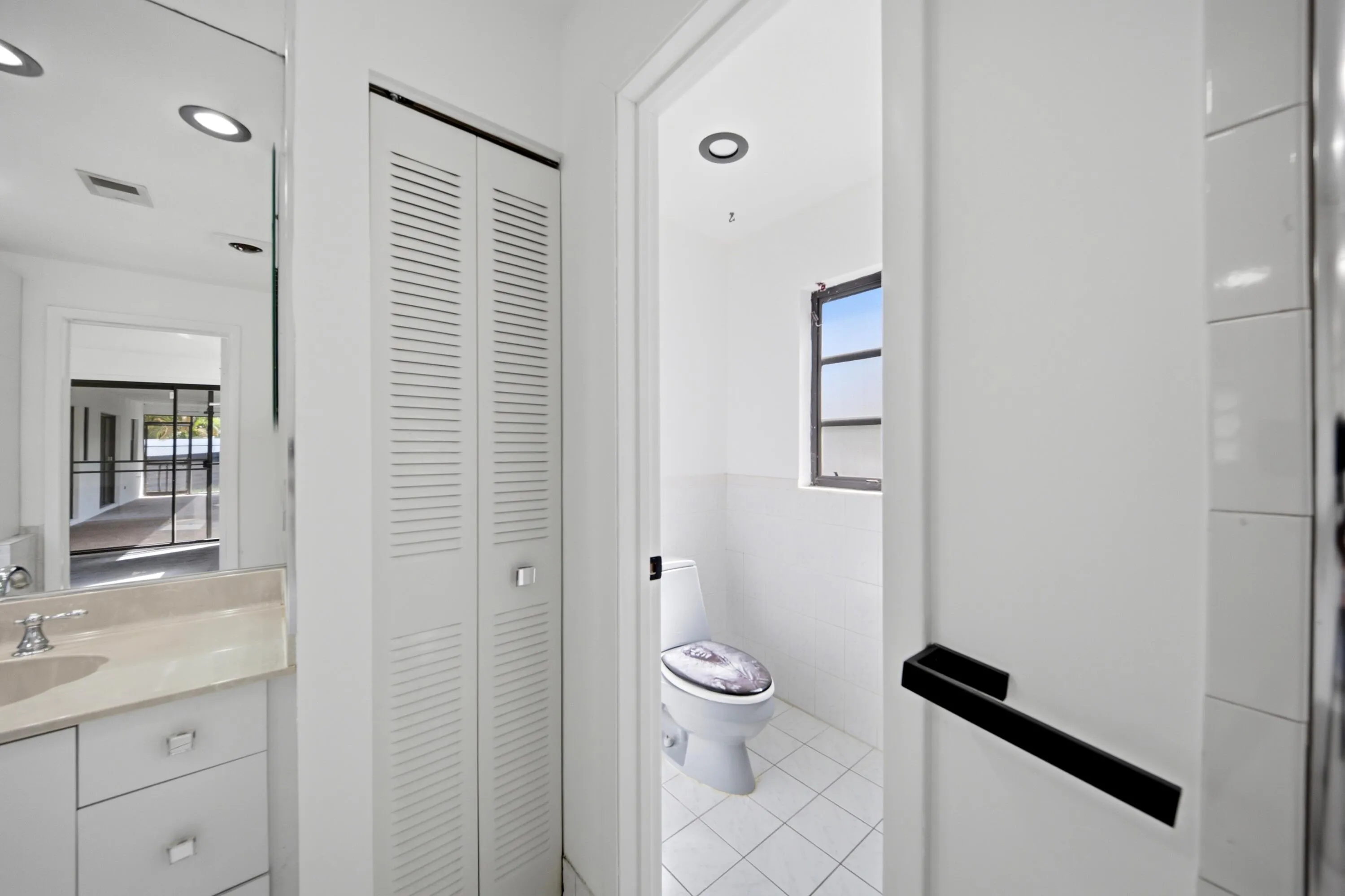 Bathroom vanity with a light-toned countertop, undermount sink, and polished chrome faucet