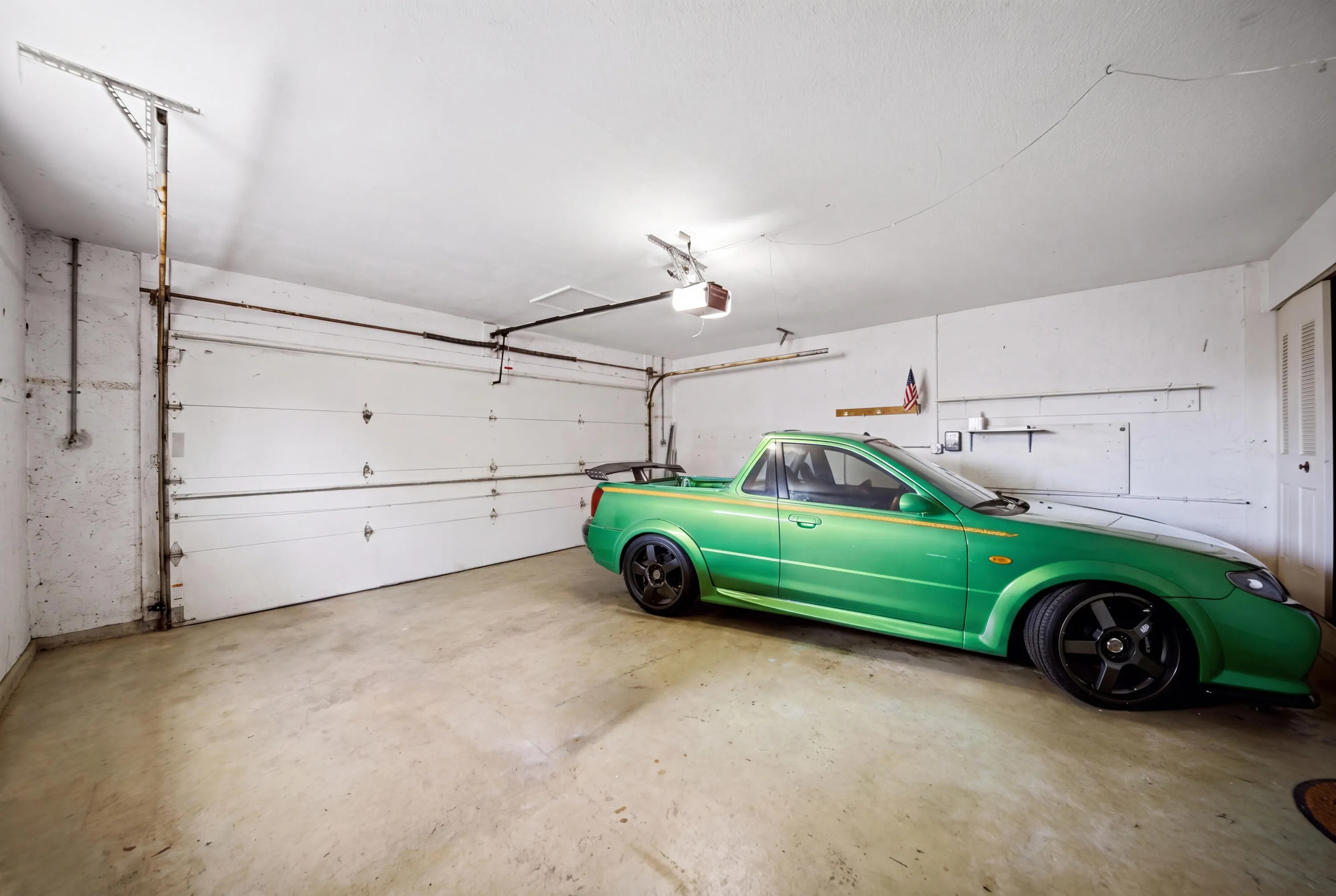 Spacious garage featuring a concrete floor, overhead lighting, and a white paneled garage door