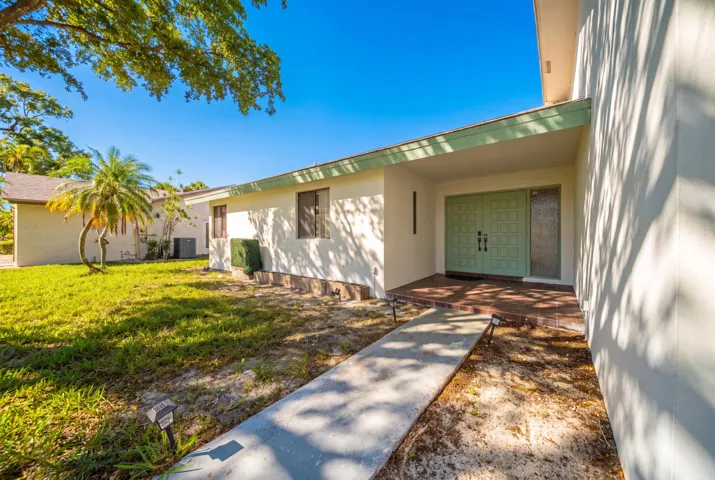 Entryway featuring double panel doors, an adjacent frosted glass sidelight, and a covered porch with a tiled floor