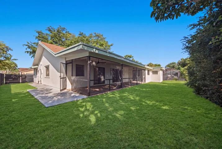 Expansive rear yard featuring a manicured lawn and mature landscaping