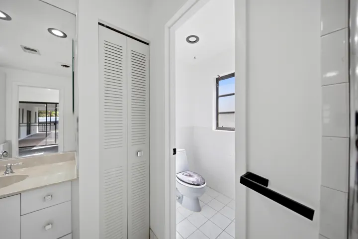 Bathroom vanity with a light-toned countertop, undermount sink, and polished chrome faucet
