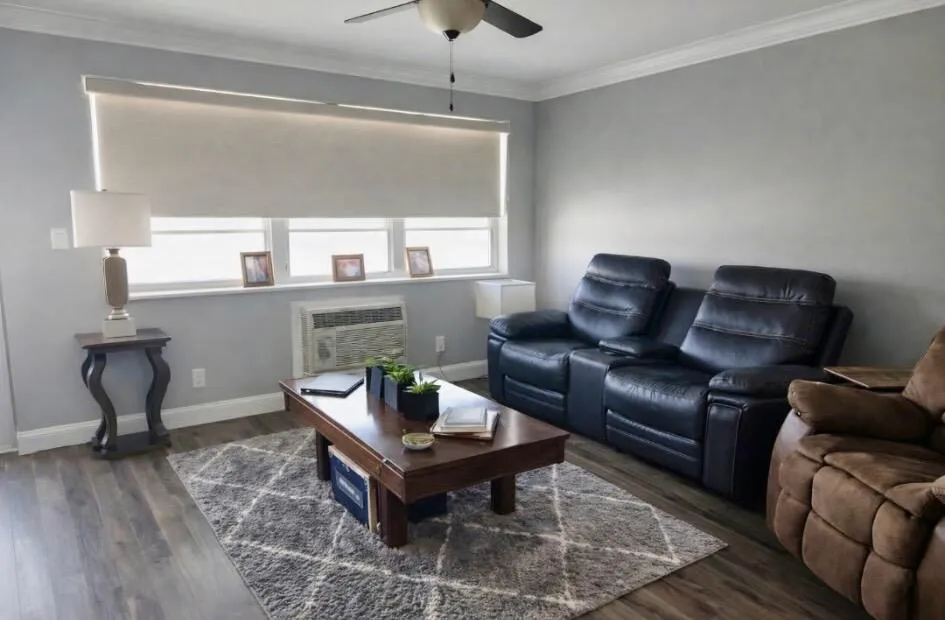 Living area featuring wood look vinyl flooring, a ceiling fan, and crown molding