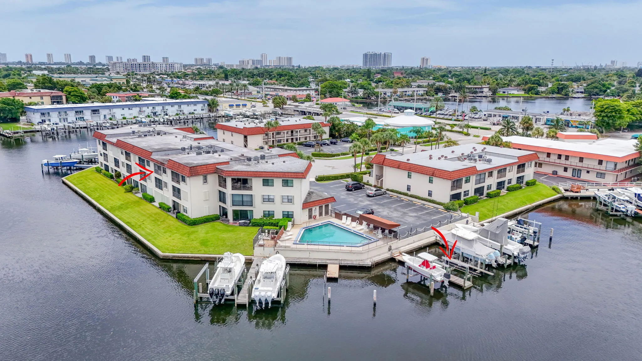 Waterfront condominium complex featuring a central swimming pool and boat slips