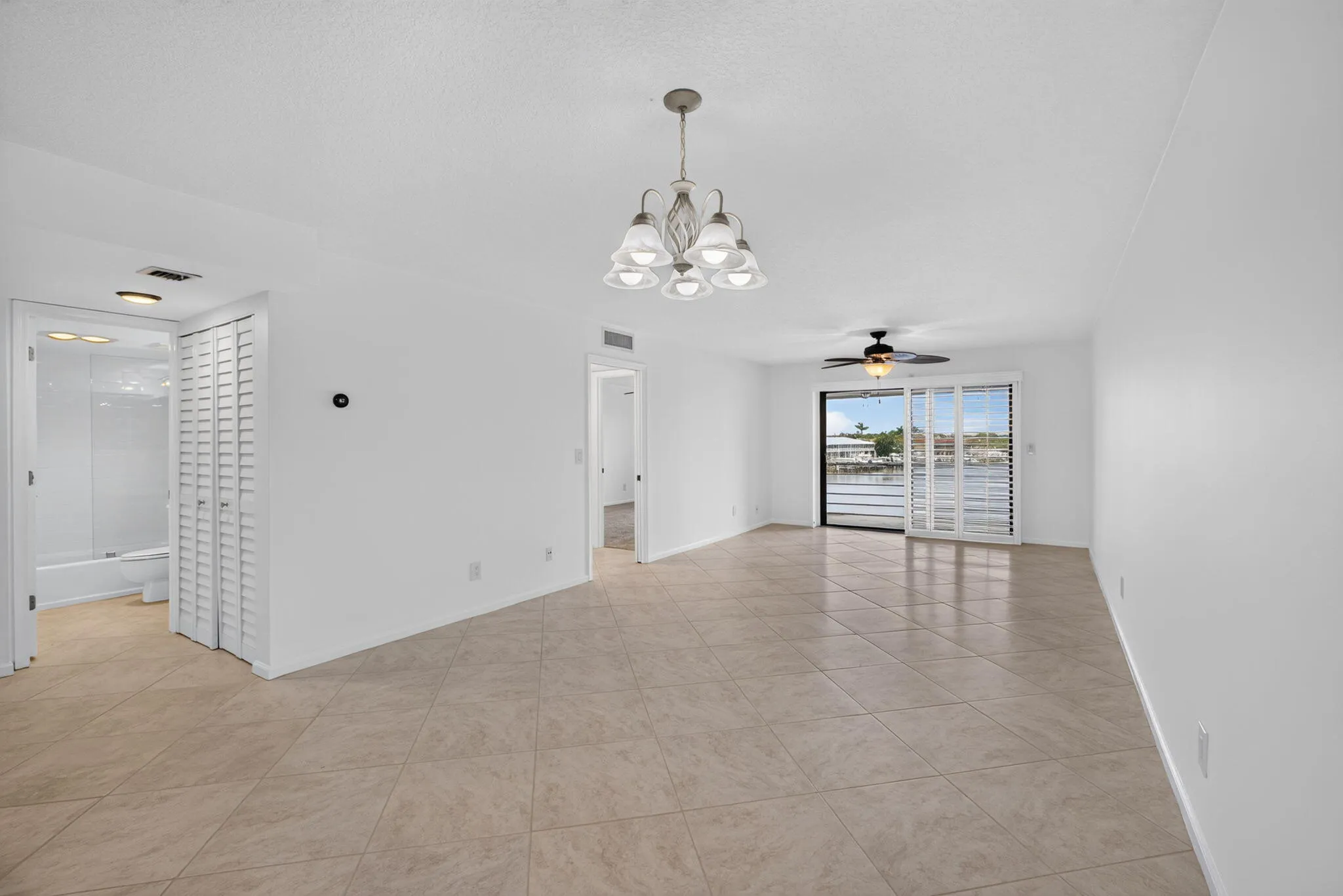 Spacious interior featuring tile flooring throughout, white walls, and a chandelier lighting fixture