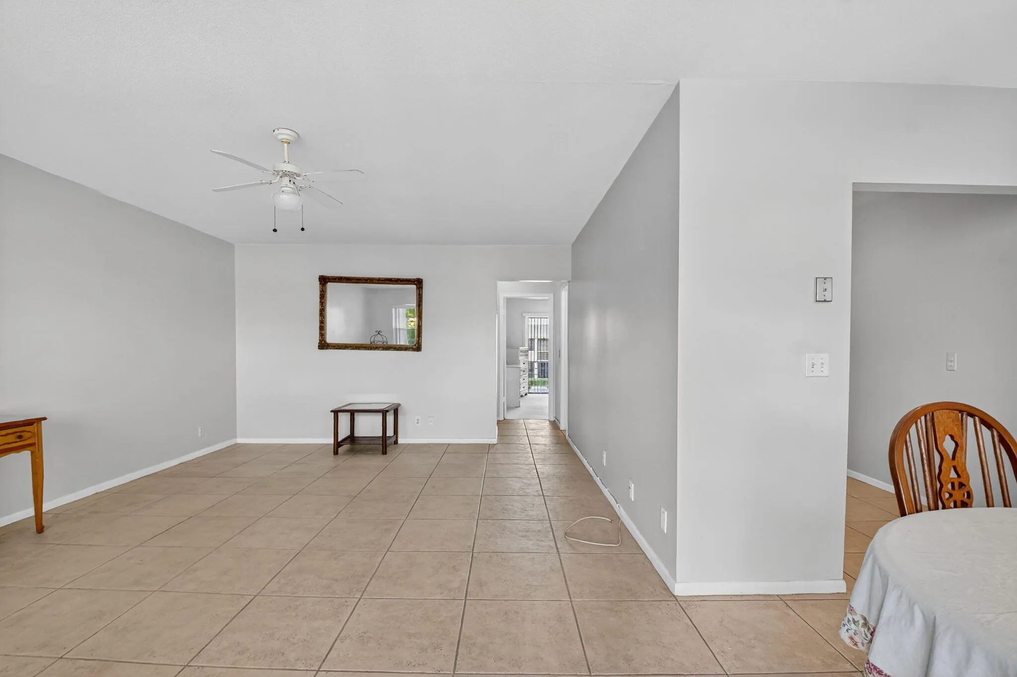 Spacious living area featuring neutral wall tones and tile flooring throughout