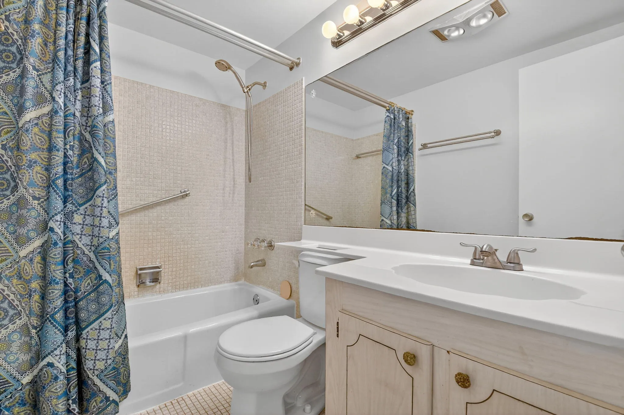 Bathroom featuring a white vanity with integrated sink, brushed nickel faucet, and a large wall-mounted mirror