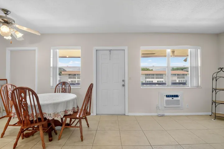 Bright interior room featuring a neutral color palette, tiled flooring, and multiple windows