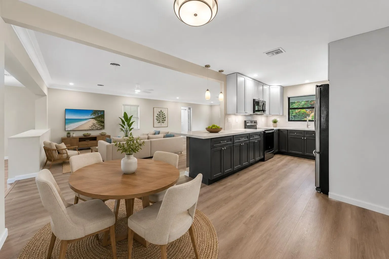 The beautifully updated kitchen opens seamlessly to the spacious living and dining areas, featuring quartz countertops, modern cabinetry, luxury vinyl plank flooring, and the open-concept layout today's buyers are searching for in a move-in ready Hollywood, FL home.