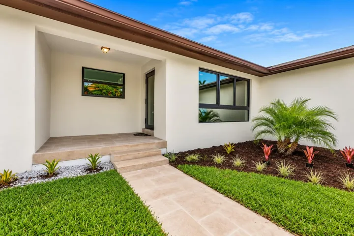 Beautiful single-story home in Hollywood, Florida featuring modern curb appeal, an attached garage, lush landscaping, and a spacious front yard just minutes from Hollywood Beach and Downtown Hollywood.