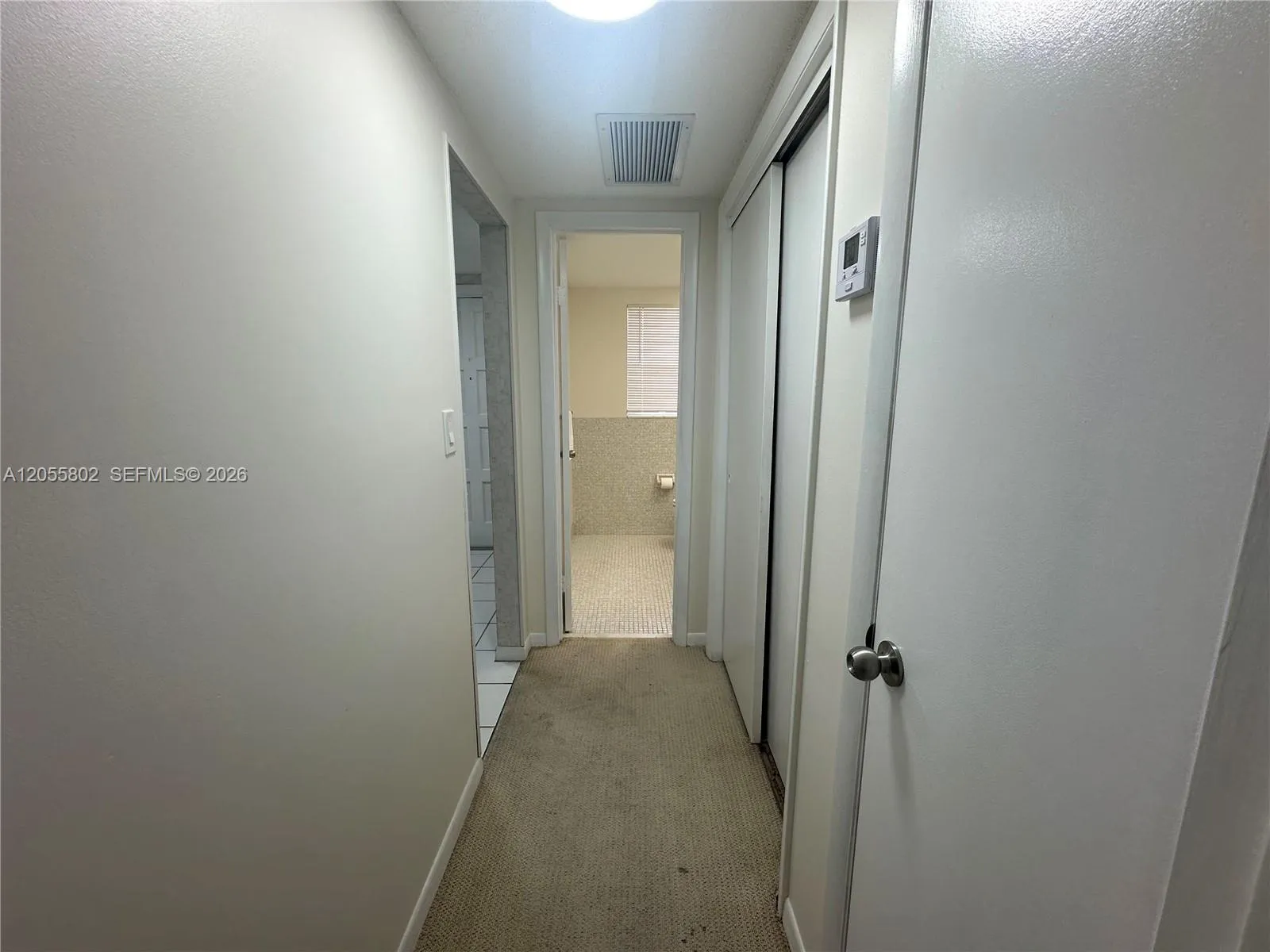 Hallway to Half Bathroom and Primary Bedroom