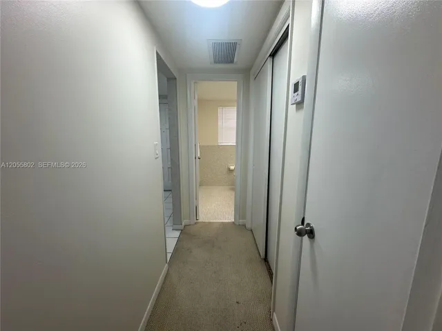 Hallway to Half Bathroom and Primary Bedroom