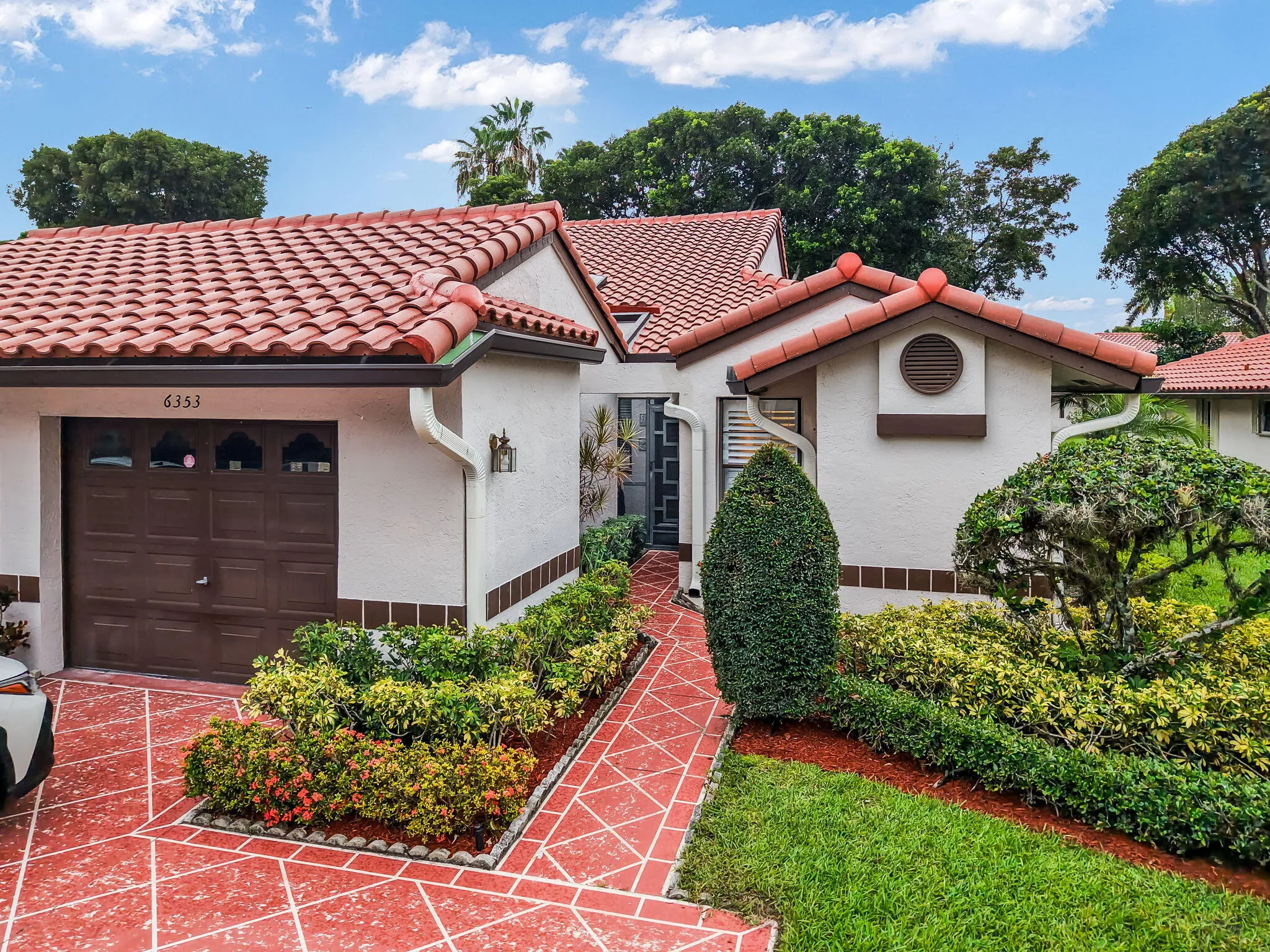 Mediterranean-style facade featuring a red tile roof and white stucco exterior