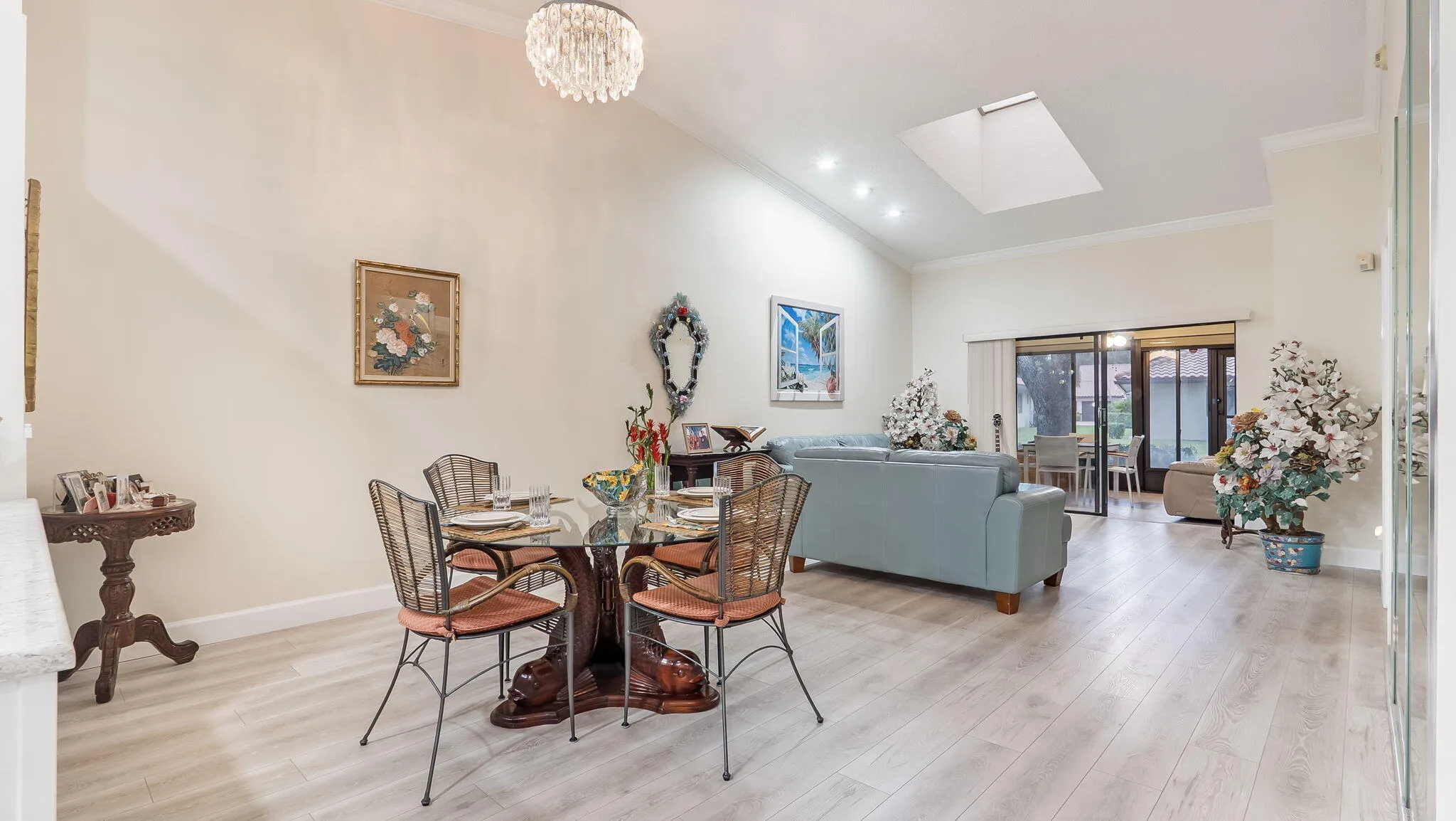 Open-concept living area featuring vaulted ceilings, recessed lighting, and a prominent skylight