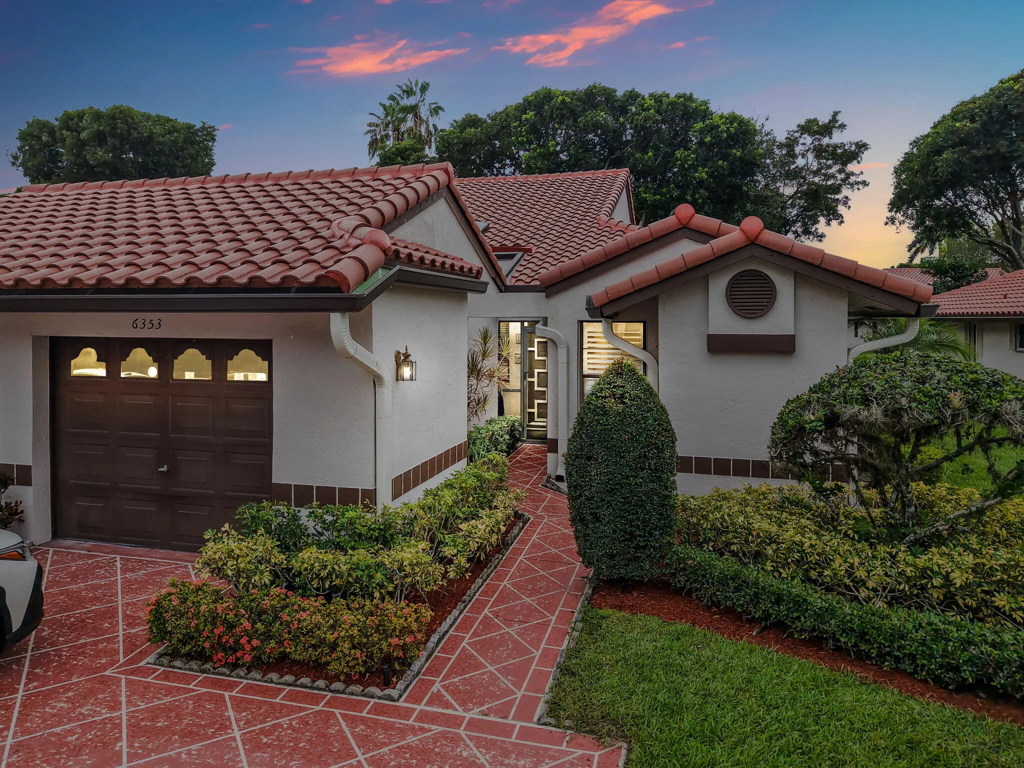 Mediterranean-style residence featuring a terracotta tile roof and textured exterior walls