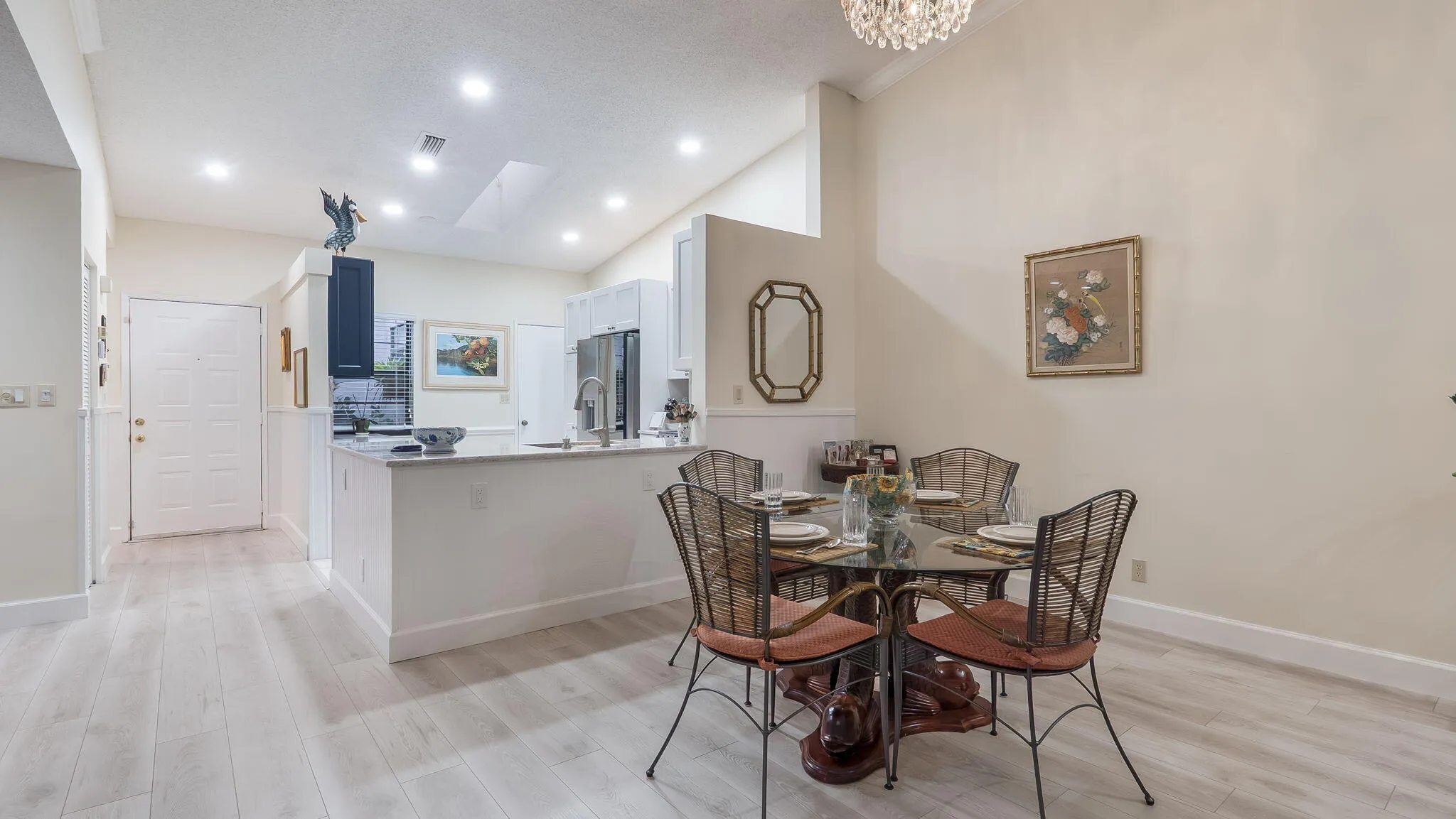 Open-concept living area featuring light wood-finish flooring, recessed lighting, and vaulted ceilings