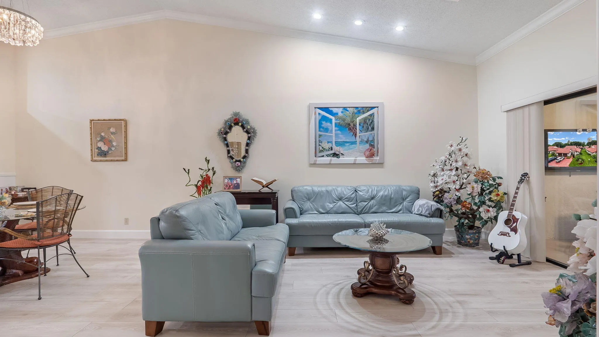 Vaulted ceiling living area featuring recessed lighting, crown molding, and light wood-finish flooring