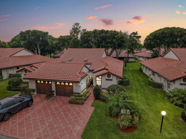 Mediterranean-style residence featuring a red tile roof and light-colored exterior