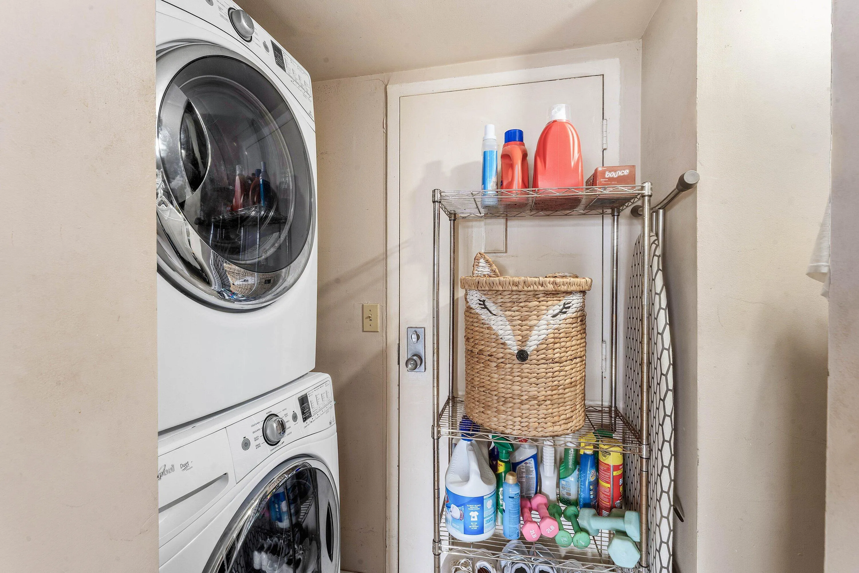 Dedicated laundry area featuring a stacked washer and dryer unit