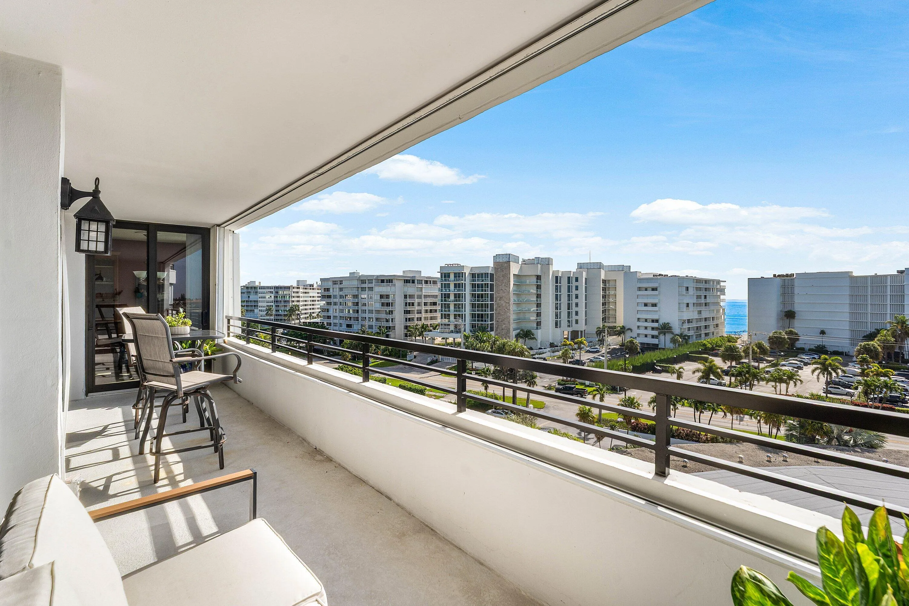 Expansive outdoor balcony with a black metal railing and concrete flooring
