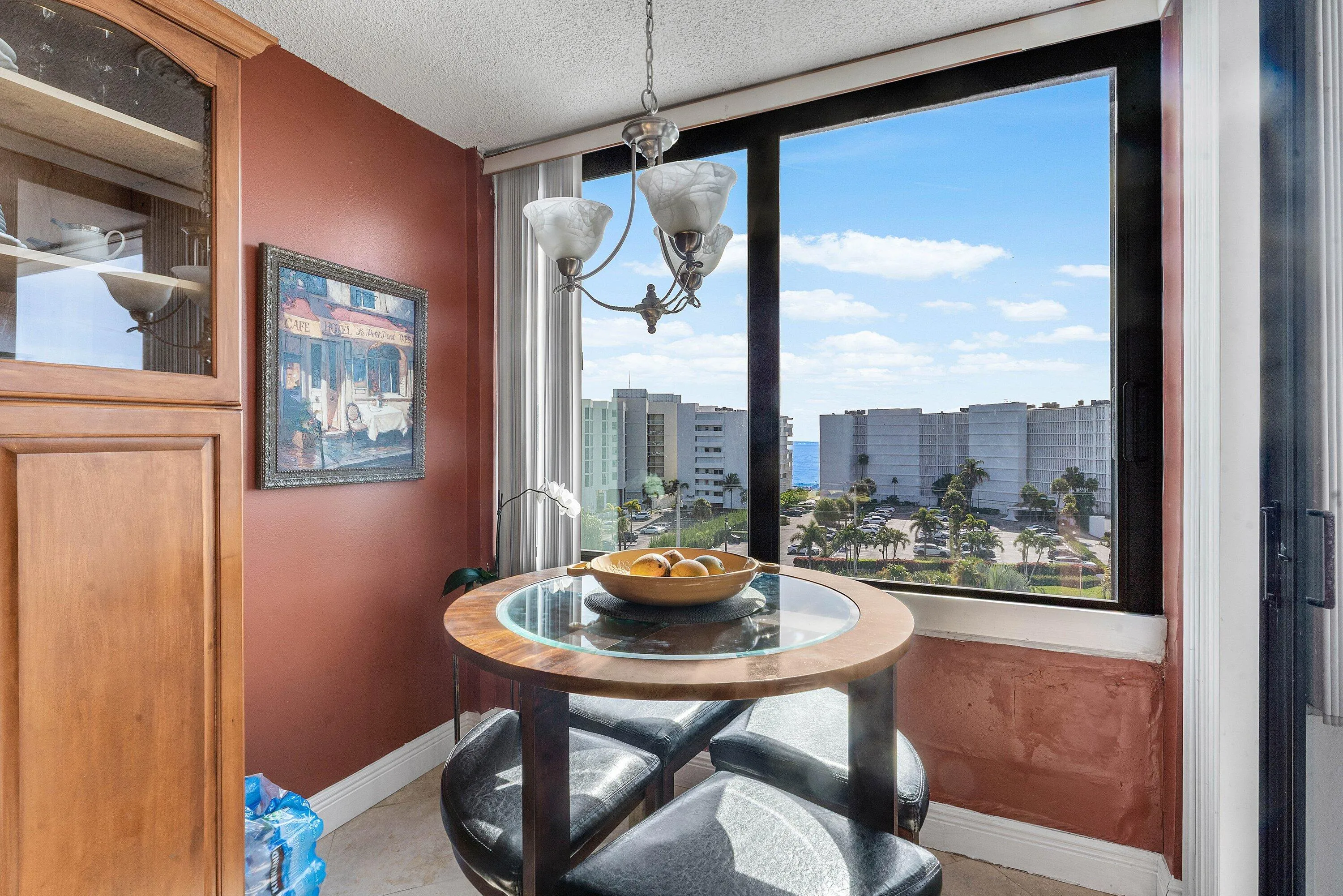 Expansive window framing coastal scenery with distant ocean views & balcony access