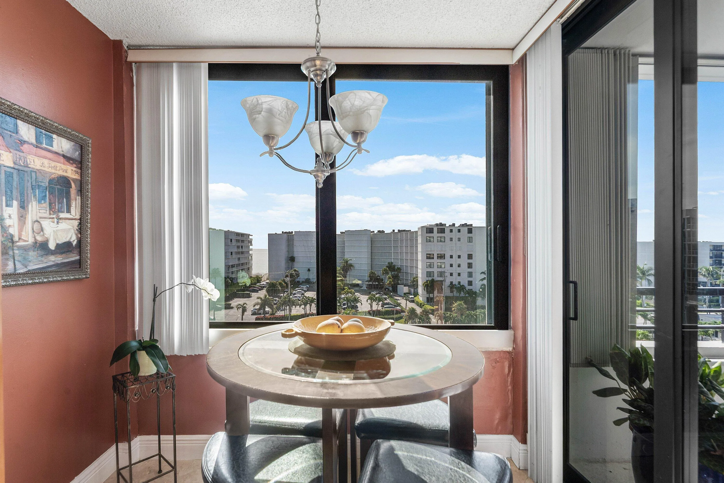 Breakfast eat-in dining featuring chandelier with frosted glass shades, and expansive windows providing cityscape and distant ocean views