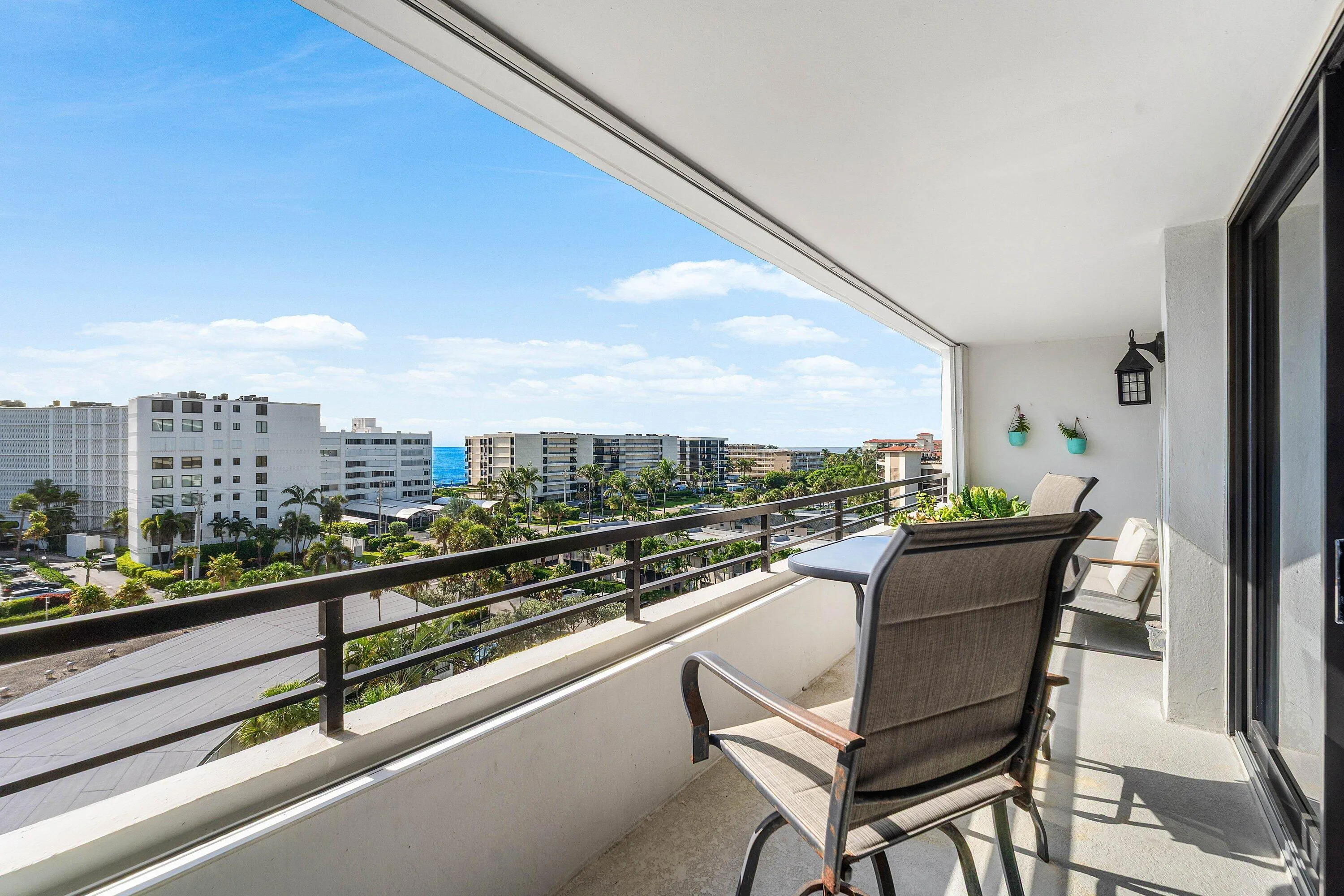 Expansive balcony featuring a black metal railing, concrete flooring, and a sliding glass door